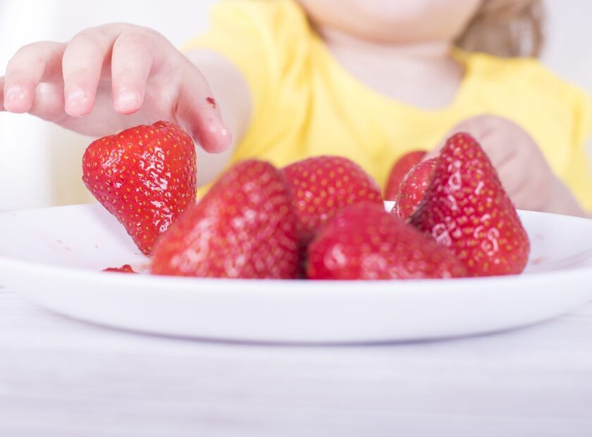 Closeup shot of a little girl eating strawberries